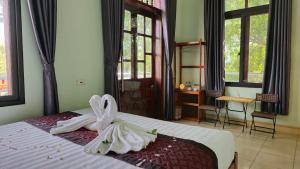 a bedroom with a bed with a dress on it at Vi TamCoc Hotel in Ninh Binh +51 photos