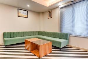 a living room with a green couch and a coffee table at Palette - Hotel Ocean Breeze in Bhopal