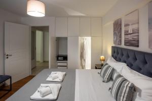 a bedroom with a large bed with two towels at KG Acropolis Escape Spa Apartment in Athens