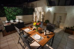 a table with plates and flowers on top of a patio at KG Acropolis Escape Spa Apartment in Athens