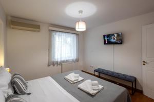a bedroom with a bed and a tv on the wall at KG Acropolis Escape Spa Apartment in Athens