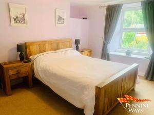 Un dormitorio con una cama grande y una ventana en Lily's Cottage, St Johns Chapel en Saint Johns Chapel