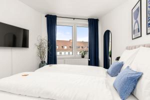 um quarto com uma cama branca e uma janela em BLU APARTMENT -modern interior design in city centre- Nähe Uni & HBF em Kassel