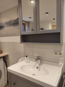 een badkamer met een witte wastafel en een spiegel bij Moarhof Ferienwohnung2 in Dietramszell