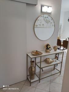 a mirror on a wall next to a shelf with vases at Apartment Milevoj in Koromačno