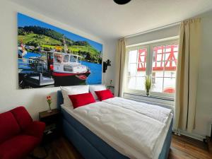 a bedroom with a bed and a painting of a boat at Ferienwohnungen Bullay in Bullay