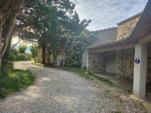 un camino de grava junto a un edificio con árboles en Villa De Alexiano, en Alixan