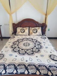 a bed with a blue and white comforter on it at Kabalana Ocean Blue in Ahangama