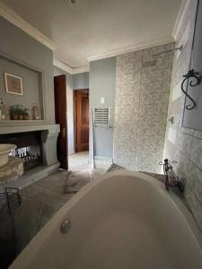 a large bathroom with a tub and a shower at Dullies Dolce in Dullstroom