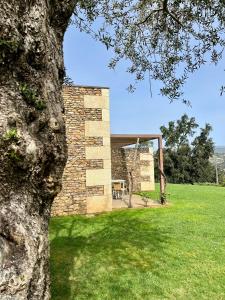 een bakstenen gebouw met een tafel in een grasveld bij Bosque da Harmonia in Arco de Baúlhe