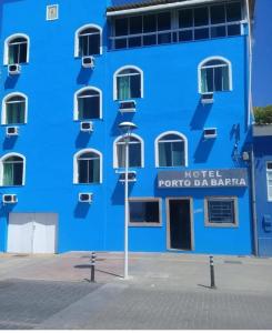 un edificio azul con una luz de la calle delante de él en Hotel Porto Da Barra, en Salvador