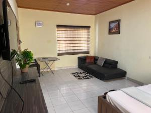 a living room with a couch and a table at Bambi Smart Homes in Otinshi