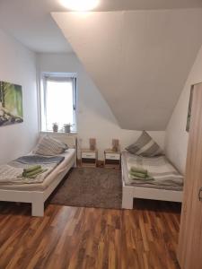 Duas camas num quarto com pisos em madeira em Teuthostel - Zimmer in der Nähe zur Veltinsarena em Gelsenkirchen