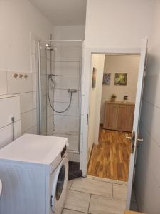 uma máquina de lavar roupa na casa de banho com um chuveiro em Teuthostel - Zimmer in der Nähe zur Veltinsarena em Gelsenkirchen