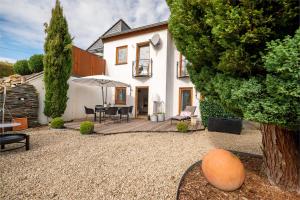 a house with a patio with a table and an umbrella at Casa Schneck in Longkamp