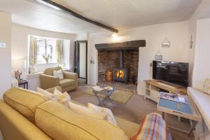 a living room with a couch and a fireplace at Syms Cottage Cutcombe in Cutcombe