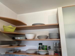a kitchen shelf with plates and dishes on it at Arbeiten Zimmer in Linz