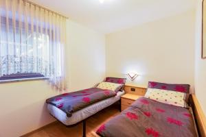 une chambre avec deux lits et une fenêtre dans l'établissement Villa Maria Moena, à Moena