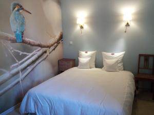 um quarto com uma cama com um pássaro azul num ramo em Envie de Sud em Vauvert
