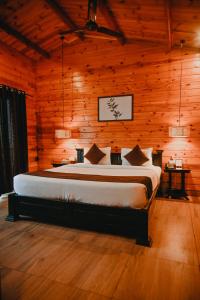 um quarto com uma cama num quarto de madeira em The Regalia Resort em Mandrem