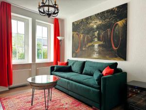 a living room with a green couch and red curtains at Ferienwohnungen Bullay in Bullay