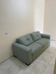 a blue couch sitting in a room at Casa 3 Quartos, 2 suites, piscina e sossego in São José da Coroa Grande