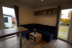 a living room with a blue couch and a table at Mobilheim ECO in Borgdorf-Seedorf