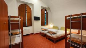 a room with two bunk beds and a room with a bed at Chiostro Delle Monache Hostel Volterra in Volterra