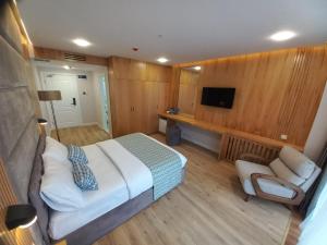 a bedroom with a bed and a couch and a tv at Hotel Black Sea in Batumi