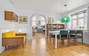 a living room with a table and chairs and a kitchen at 4 Bedroom Cozy Home In Lgstr in Løgstør