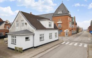 a white building with a black roof on a street at 4 Bedroom Cozy Home In Lgstr in Løgstør