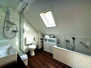 a bathroom with a tub and a shower and a toilet at Ferienwohnungen Bullay in Bullay