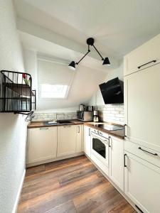a large kitchen with white cabinets and a window at Ferienwohnungen Bullay in Bullay