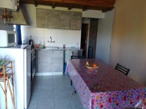 a kitchen with a table with a bowl of fruit on it at Cabañas Alicia in San Rafael