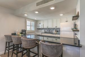 a kitchen with bar stools and a white refrigerator at SOUTH SEAS BEACH VILLA 2428 in Captiva