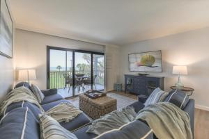 a living room with a blue couch and a fireplace at SOUTH SEAS BEACH VILLA 2428 in Captiva