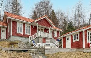 a red house with two chairs in front of it at Amazing Home In Eiksund With Kitchen 