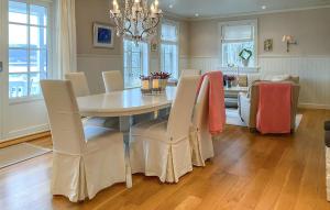 uma sala de jantar com uma mesa e cadeiras e um sofá em Amazing Home In Eiksund With Kitchen 