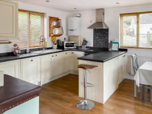 a kitchen with white cabinets and black counter tops at The Hurstings in Bridgnorth