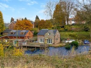 a home on a river with a wooden house at The Hurstings in Bridgnorth