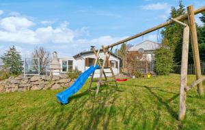 einen Spielplatz mit einer blauen Rutsche im Hof in der Unterkunft Ferienhaus Auf Dem Sand 