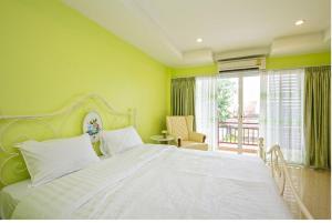 a bedroom with a large white bed and a balcony at Takanta Place in Udon Thani +58 photos