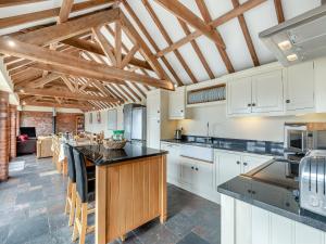 a kitchen with white cabinets and black counter tops at Ings Barn in Thorpe Saint Peter