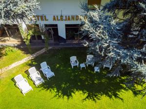 einen Blick über einen Garten mit Stühlen und ein Gebäude in der Unterkunft Alejandro in Junín de los Andes