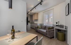 uma sala de estar com um sofá e uma mesa com copos de vinho em Cozy Apartment In Novi Vinodolski With Kitchen em Novi Vinodolski
