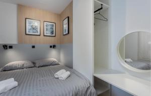 um quarto branco com uma cama e um espelho em Cozy Apartment In Novi Vinodolski With Kitchen em Novi Vinodolski