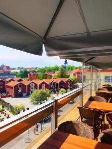 a balcony with tables and chairs and a view of the campus at Quality Hotel Statt in Hudiksvall