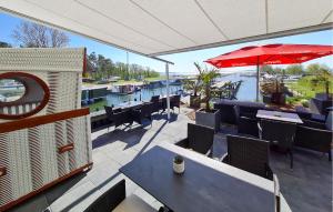 Un patio con mesas y sillas y una sombrilla. en Hausboot Relax, en Sagard 20 fotos más