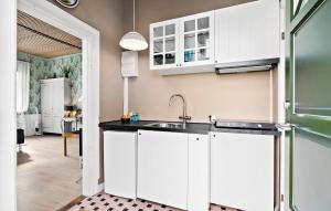 a kitchen with white cabinets and a sink at Beautiful Apartment In Aakirkeby With Wifi in Åkirkeby