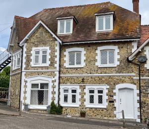 a brick house with white windows on a street at Beach Court - Beer Devon in Beer